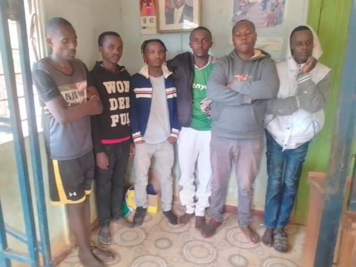 Six suspects arrested in connection with a highway robbery in Mbooni East Sub-County are escorted by police officers during processing at Mbumbuni Police Station ahead of their arraignment in court.
