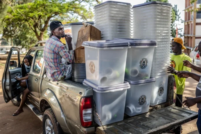 Uganda Elections Young electoral officials ride on a pickup truck carrying ballot boxes and other electoral materials for dispatch at a polling station serving as a dispatch centre during final preparations ahead of Uganda’s 2026 general elections, in Kampala on January 14, 2026.