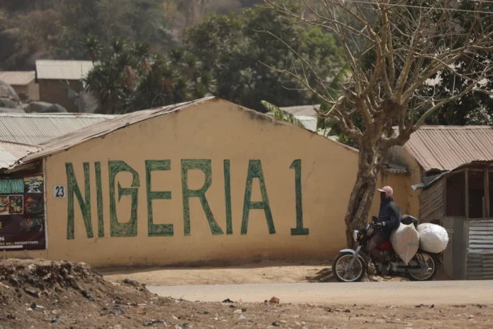 AFP__20240209__34HW3HP__v1__HighRes__NigeriaReligionUnrest-og_image A man ride his motorcycle at an area of abandoned houses belonging to people displaced by violence in the Derkong community of Mangu on February 2, 2024, following weeks of intercommunal violence and unrest in the Plateau State.