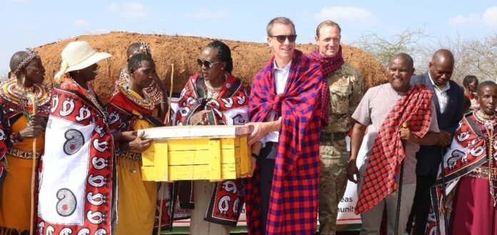 Acting British High Commissioner to Kenya Ed Barnett and Defence CS Soipan Tuya hand over beehives donated by BATUK to Ilmotiok Women’s Group.
