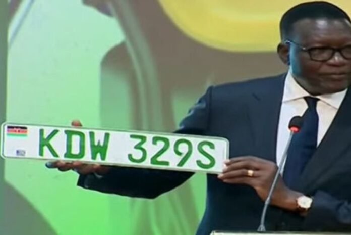 BeFunky-photo (43) Transport Cabinet Secretary Davis Chirchir displays the newly unveiled green number plate for electric vehicles during the launch of Kenya’s National Electric Mobility Policy at the Kenyatta International Convention Centre in Nairobi on February 3, 2026.