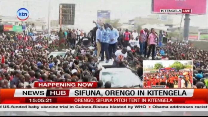 A TV broadcast captures the massive crowd at Kitengela as chants of “Ruto Must Go” echo during the high-stakes ODM rally.