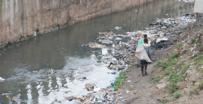 Street children walk along the banks of the heavily polluted Nairobi River.