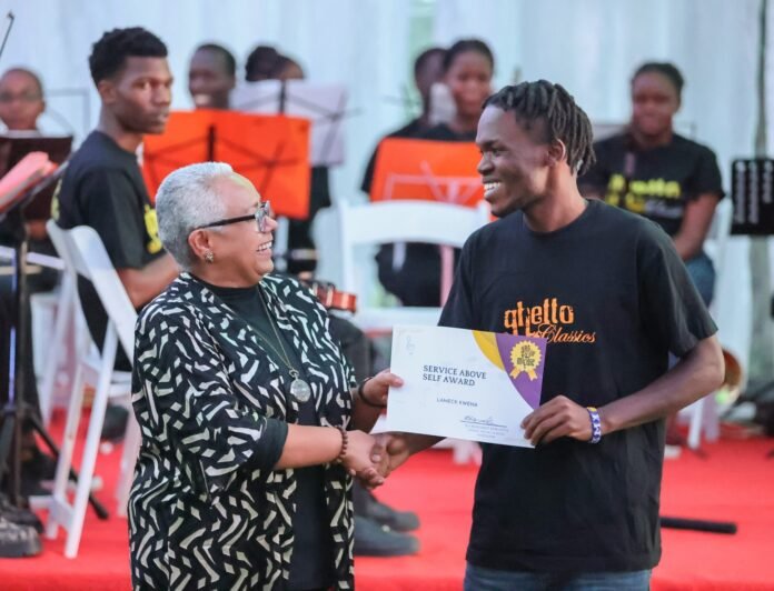 Former First Lady Margaret Kenyatta presents an award to a participant during the Ghetto Classics Charity Golf Tournament at Migaa Golf Club in Kiambu County, where she lauded the programme’s role in empowering young people through music and mentorship.