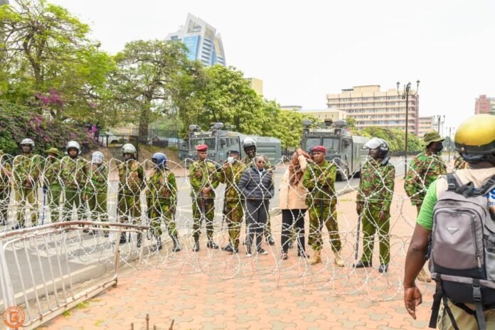 Police stand behind razor wire barricades during the June 25 Gen Z anniversary protests in Nairobi.